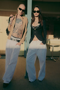 Pleated White Jeans worn by two models at a motel — Confession Road campaign