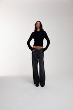 Frame Knitted Hoodie in Black and Trace Cut Denim Jeans in Meteorite Black worn by female model