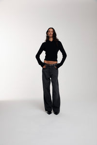 Frame Knitted Hoodie in Black and Trace Cut Denim Jeans in Meteorite Black worn by female model