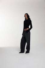 Frame Knitted Hoodie in Black and Trace Cut Denim Jeans in Meteorite Black worn by female model