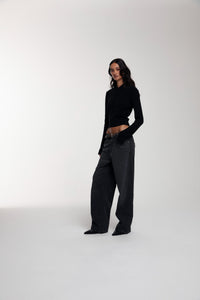 Frame Knitted Hoodie in Black and Trace Cut Denim Jeans in Meteorite Black worn by female model