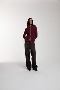 Engineered Zip Cardigan in Oxblood and Trace Cut Denim Jeans in Chocolate Brown worn by female model